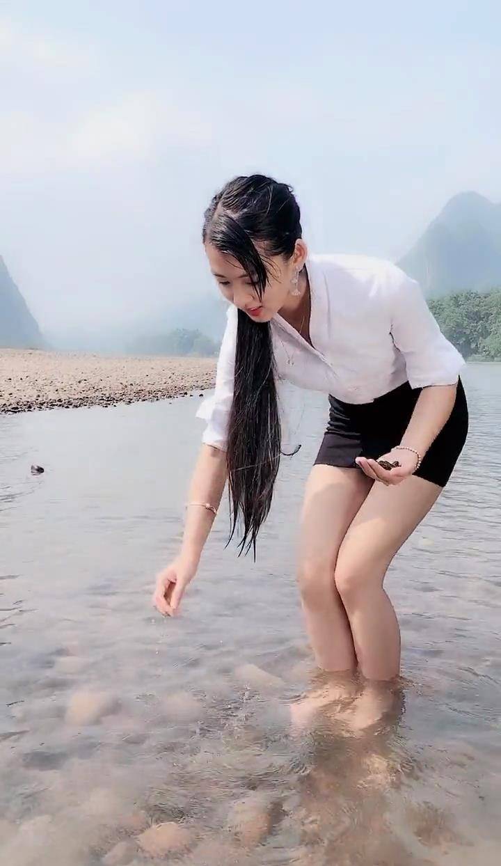 河里玩耍的美女穿着短裙，看她蹲下的姿势，这才是真女神