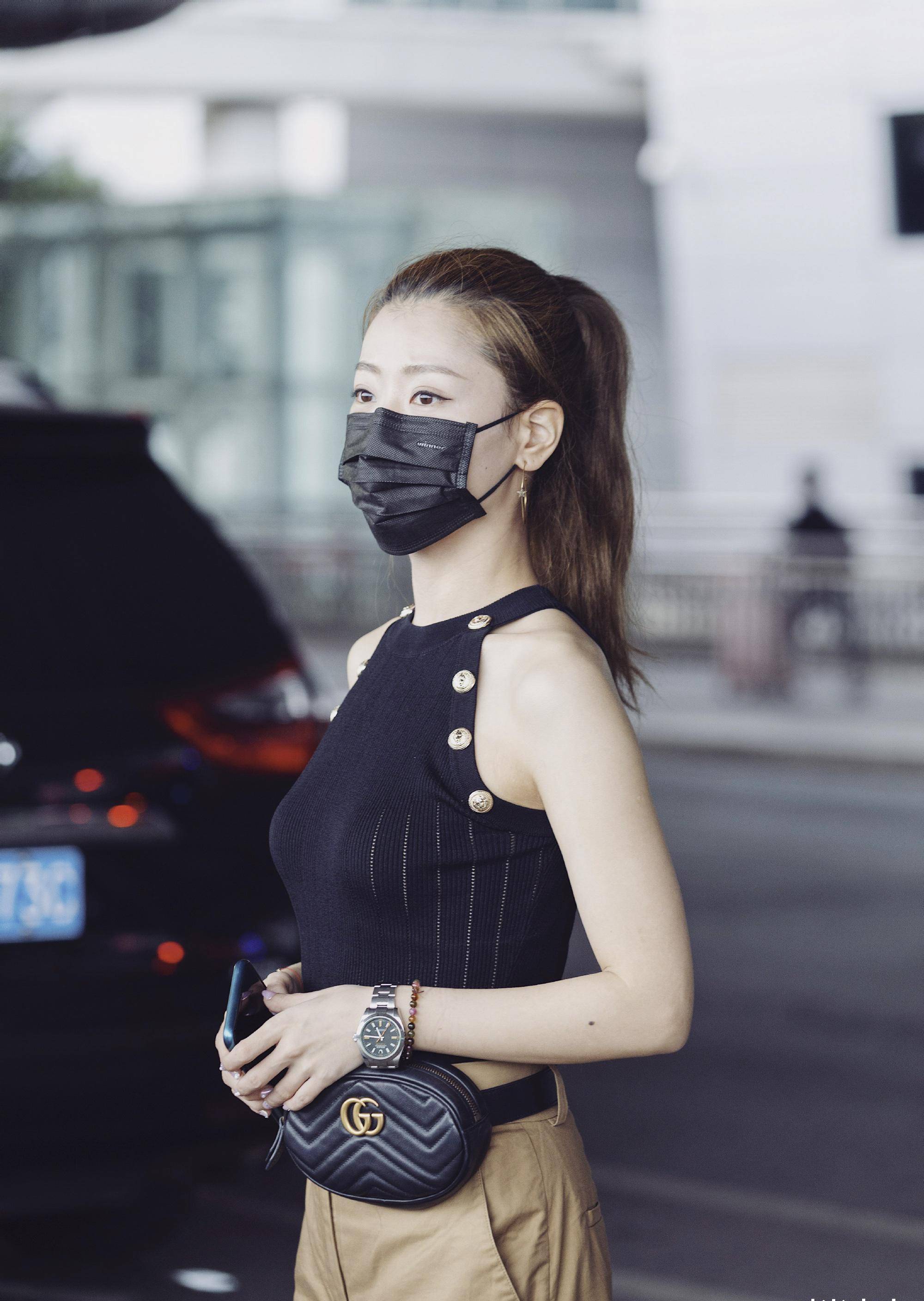 白冰以一件黑色无袖挂脖上衣搭配卡其色高腰阔腿长裤,高马尾造型让人