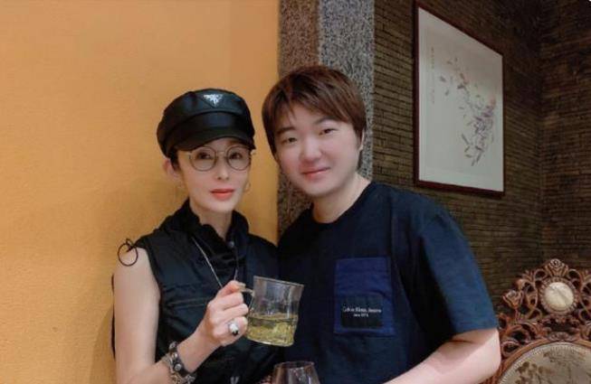 照片中,女神张敏站在左侧,吴彤站在右侧.两个人都拿着眼镜,面带微笑.