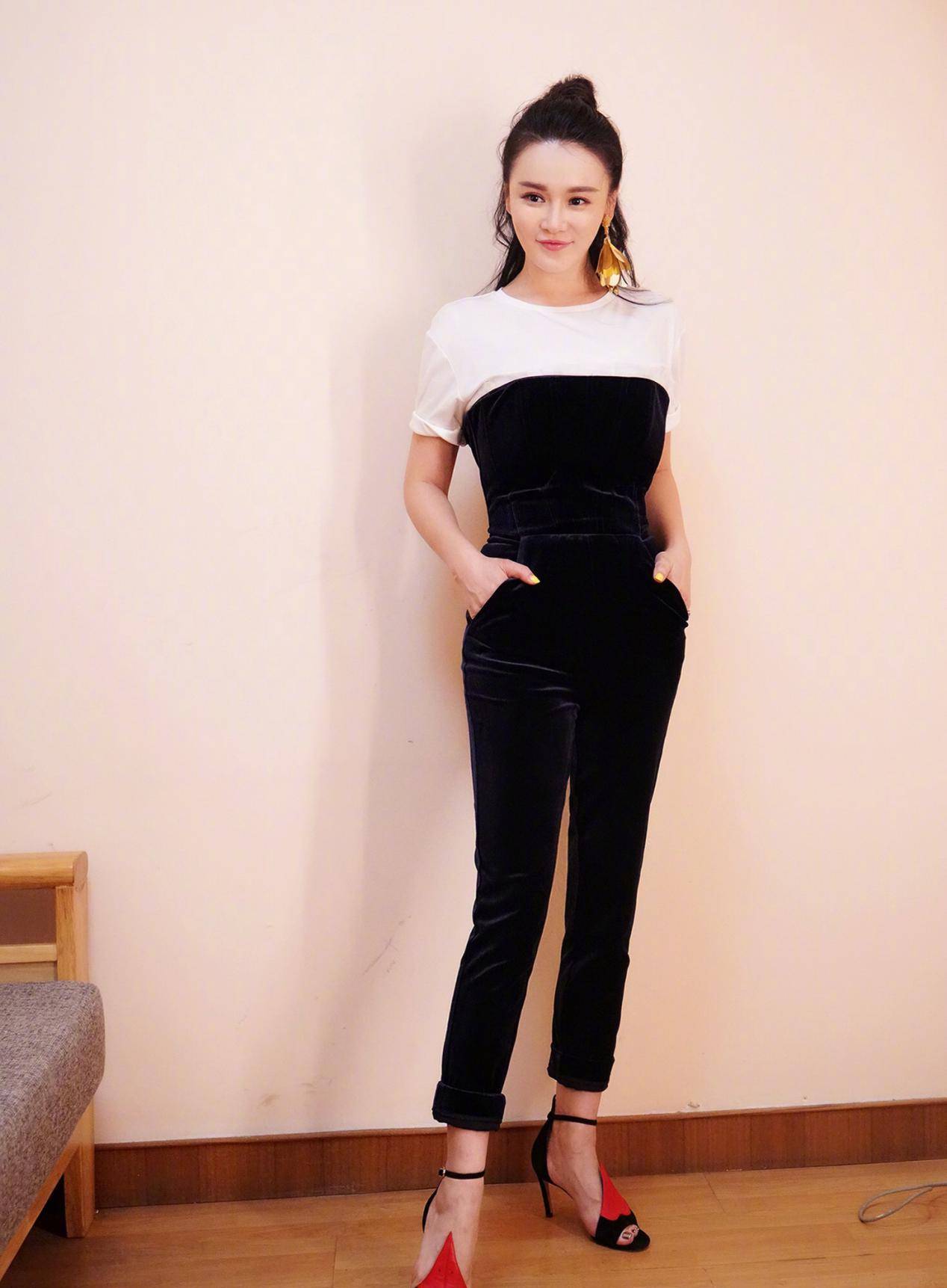 微微时尚的白色上衣隐隐约约的展现了冉莹颖的肌肤,紧身的牛仔吊带使