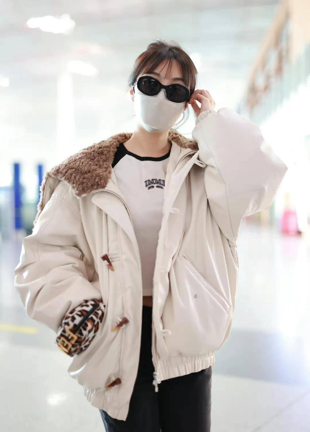 李菲儿走机场穿白色翻毛领夹克搭黑色牛仔裤清新时尚显身材
