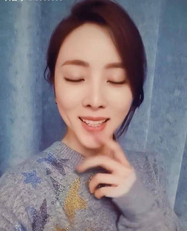 视频中,李思思身穿灰色印花毛衣,脸上留着一缕头发.