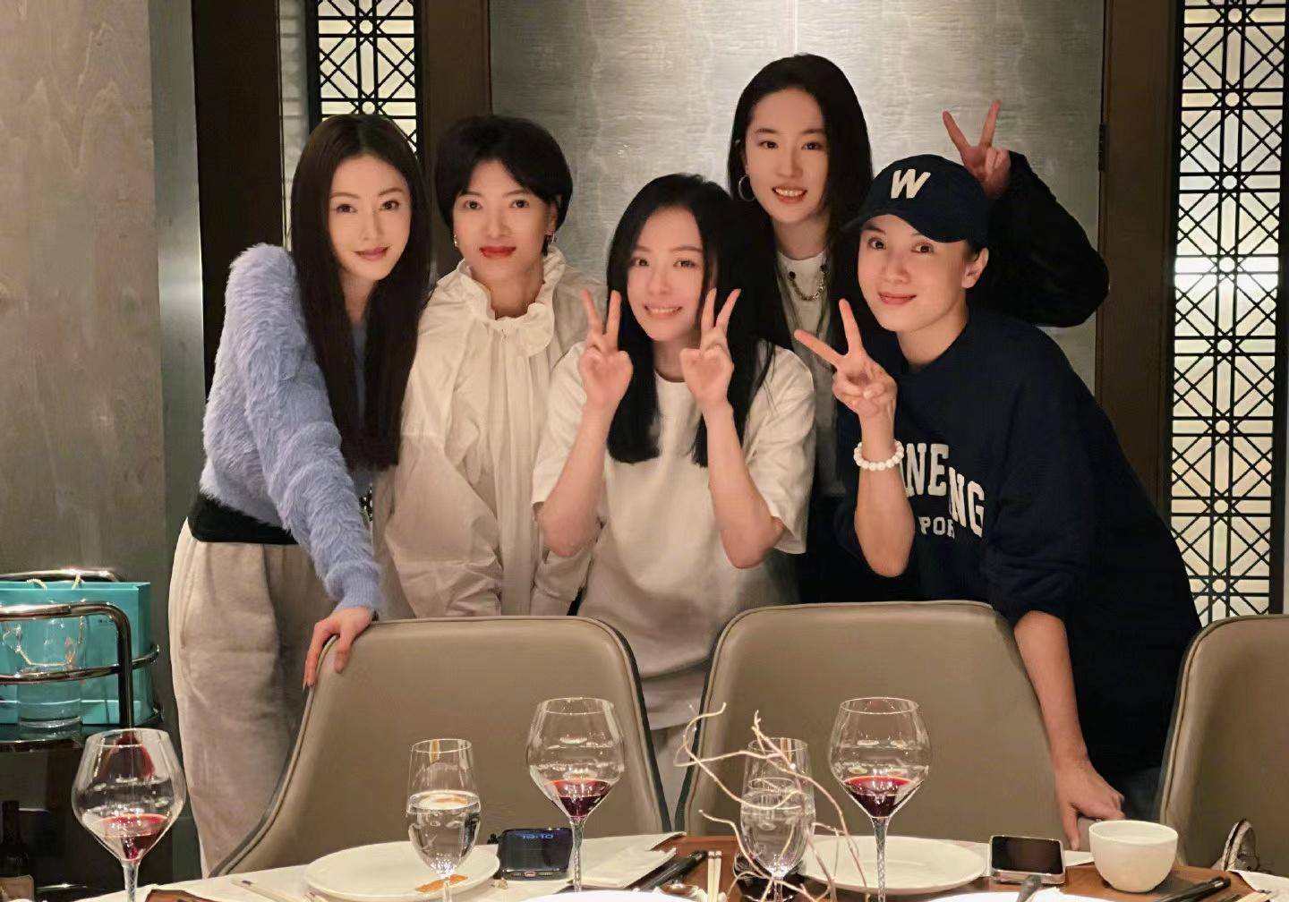 从合影中可以看到,其中一位男士站在张靓颖和张天爱中间,并且把手搭在