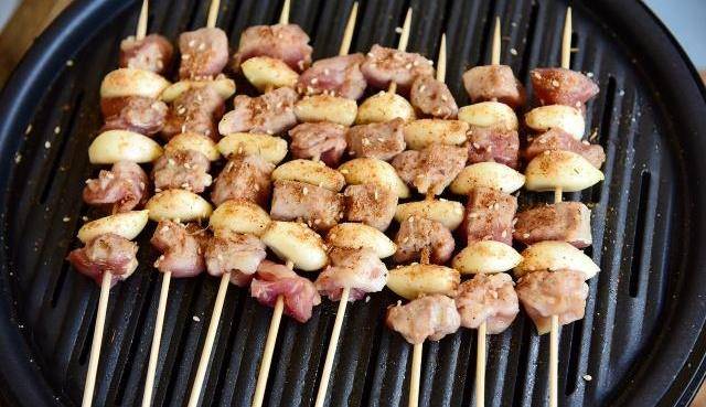 6,时不时的翻个面,撒些万能烧烤料.7,直至蒜瓣肉烤熟了即可.