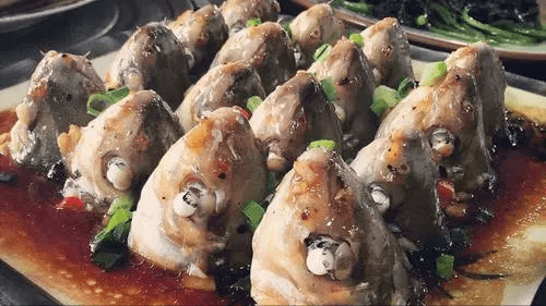 比如大名鼎鼎的"仰望星空",一个黑乎乎的鱼头立在盘子上,盘子里面不