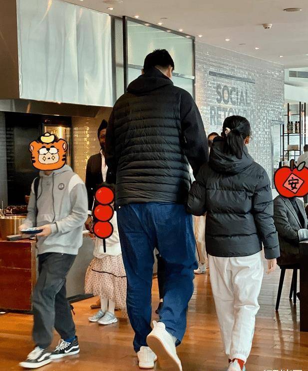 照片中,姚明身穿黑色棉袄,脚踩运动鞋,身材魁梧比旁边的路人壮两倍,一