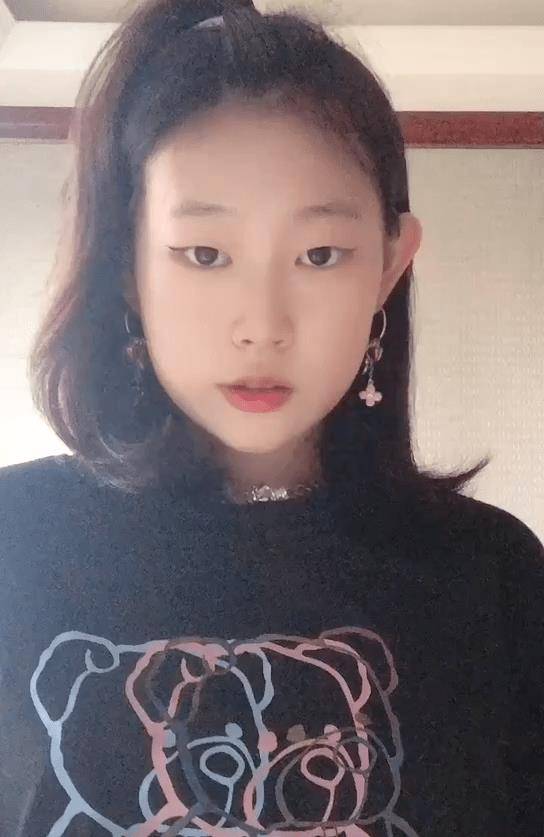 短片中,沈佳润身穿黑色t恤,中长发型,头顶绑着"歪桃辫儿",前卫而又不