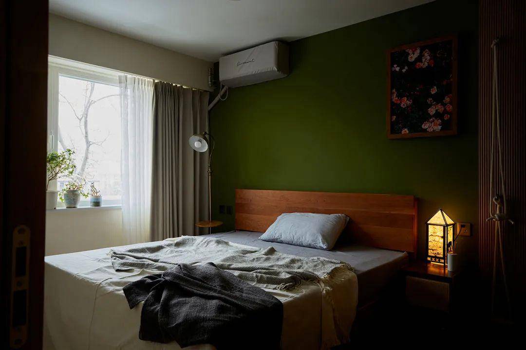 卧室,床头背景墙涂刷了草绿色乳胶漆,搭配上橡木材质的床,以及床边