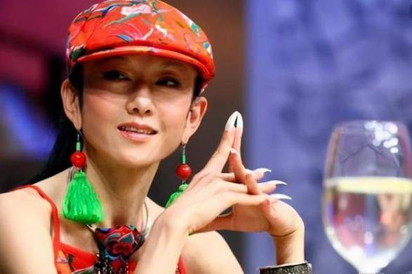 杨丽萍整整10年的时间都没有摘下帽子,就算不戴帽子的时候也会用花饰