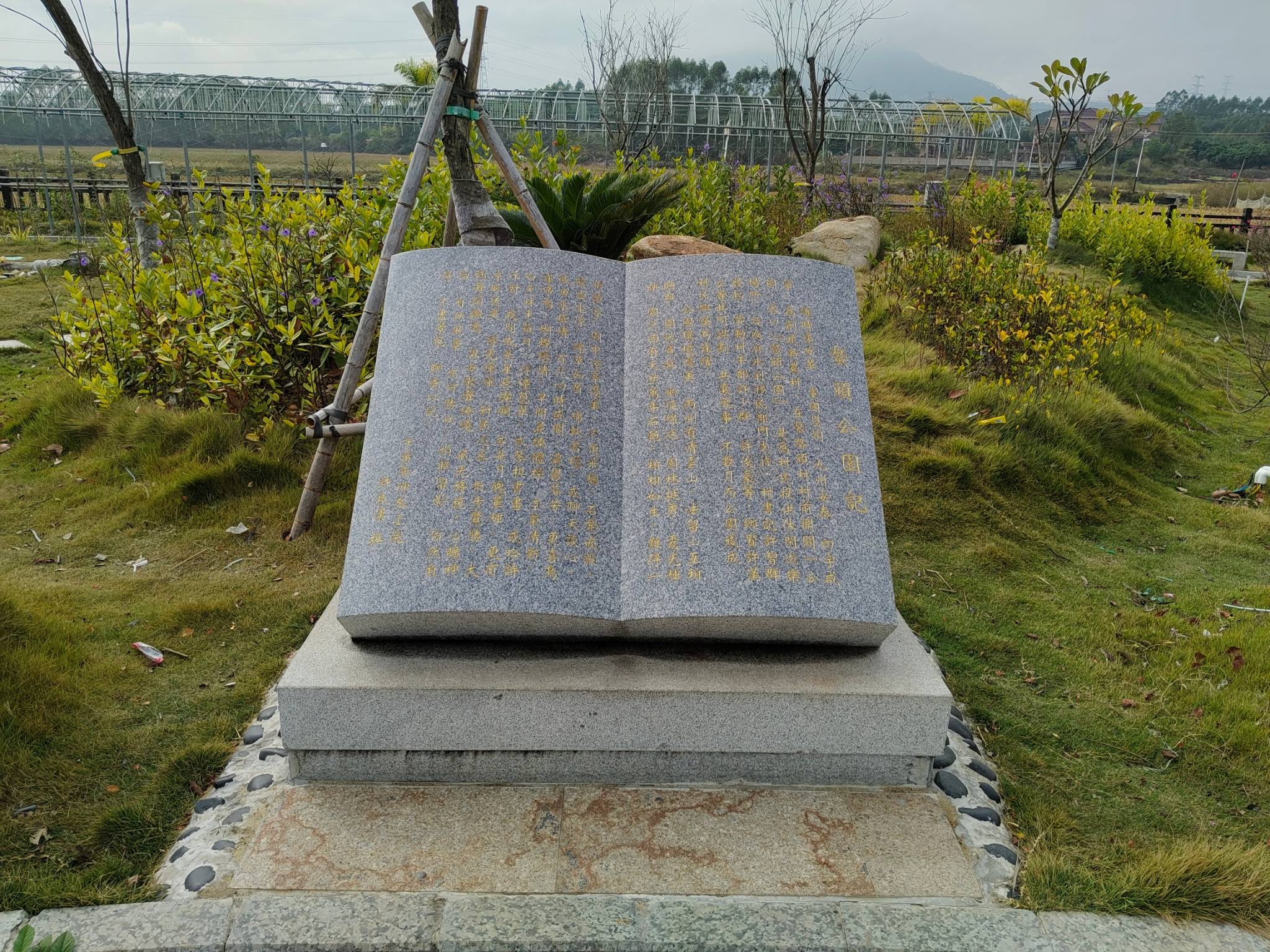 在这宁静的草地上,一座巨大的书形石碑矗立其中,宛如一位沉默的守护者