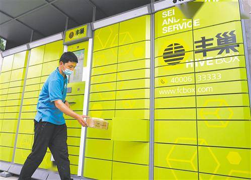 5月12日,一名快递员在北京市丰台区一处丰巢快递柜前存放快件.