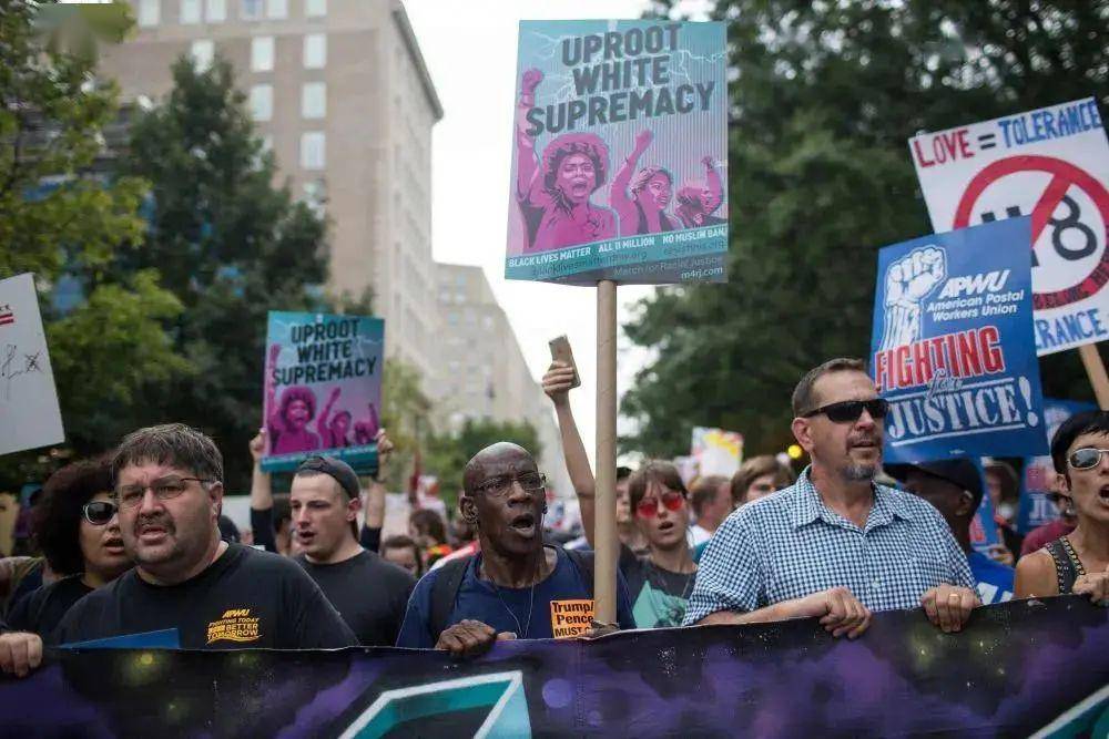 2018年8月12日,在美国首都华盛顿,人们举着反对极右势力的标语牌参与