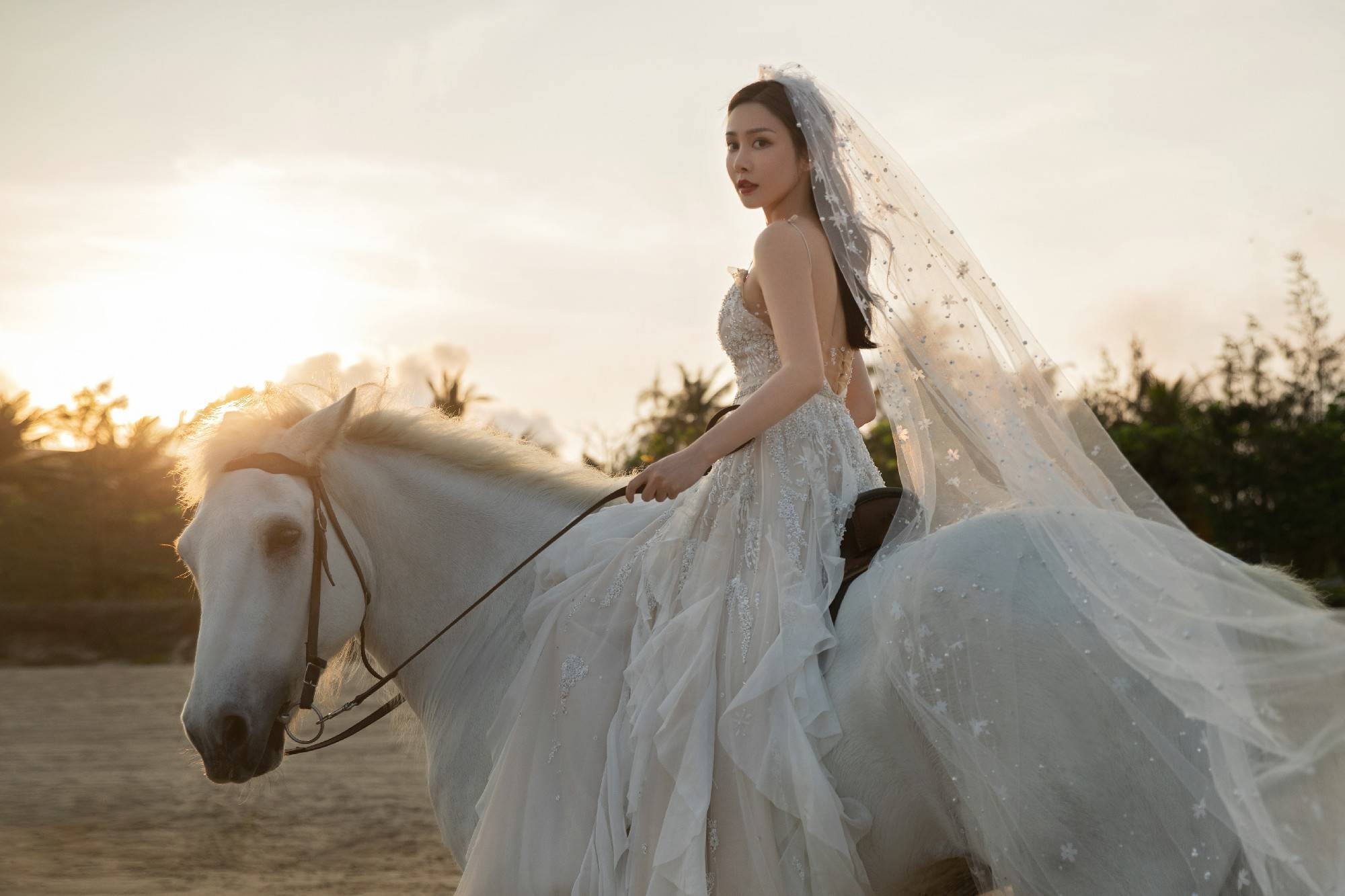 1/ 12 近日,演员林籽透过工作室公开了一组海边婚纱照,身披白纱的她骑