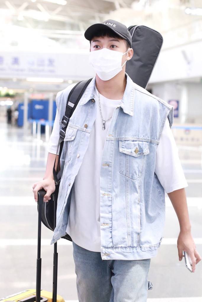 伍嘉成一身牛仔套装现身机场背吉他酷帅十足