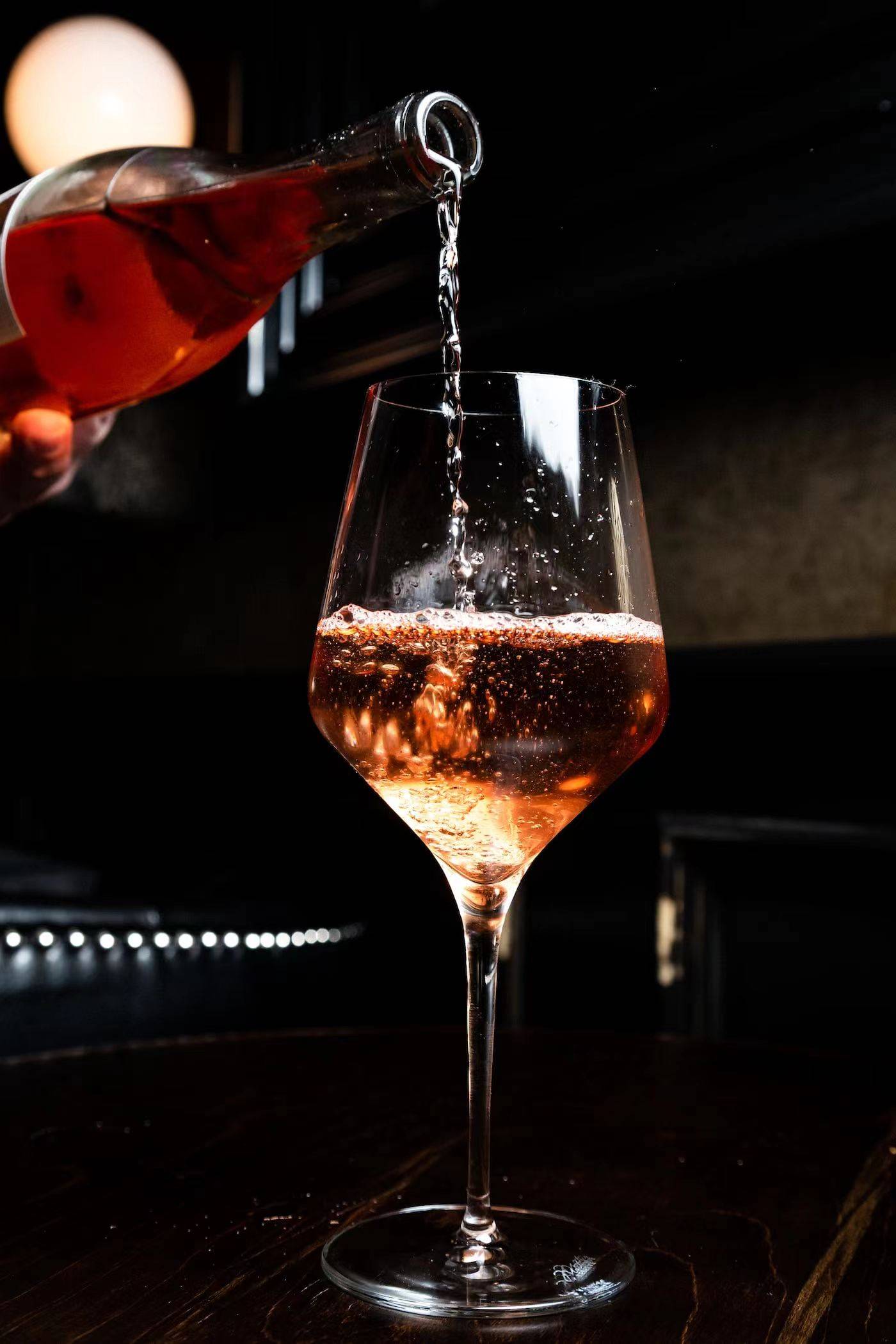 将葡萄酒倒入杯中倾斜45°,最好置于白色背景板下:观察葡萄酒酒液中