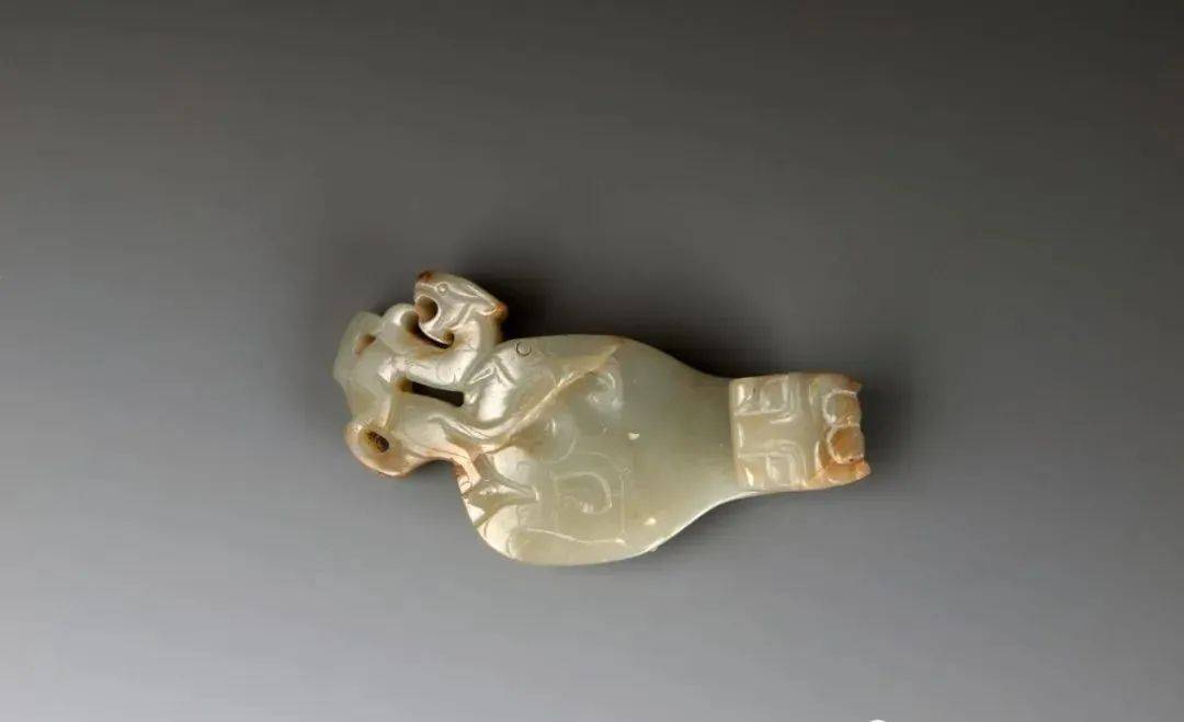 白玉,玉带钩呈扁平状,有深褐色沁斑.