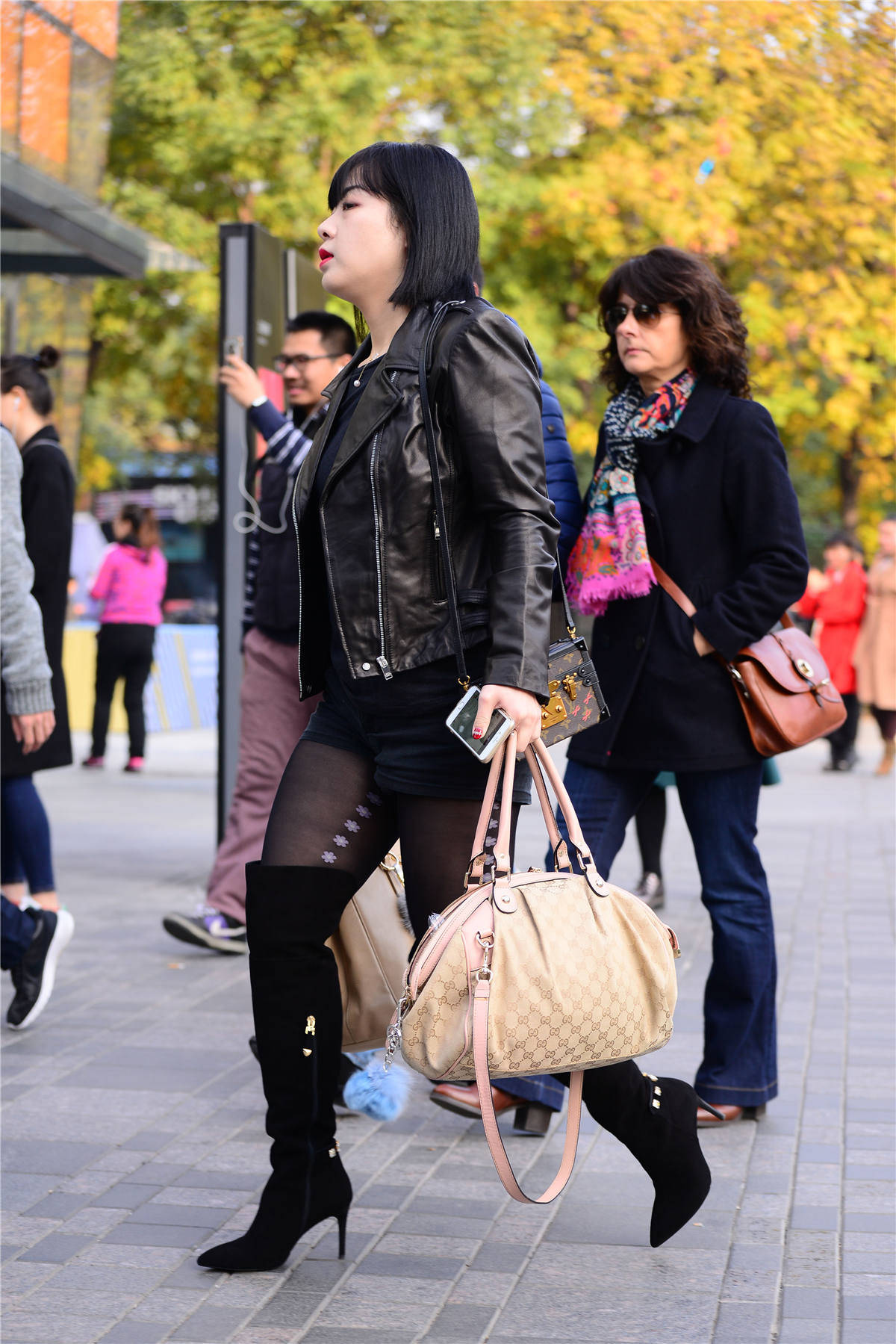 6厘米的尖头细跟过膝靴,搭配黑色丝袜和短裤,黑色的皮夹克