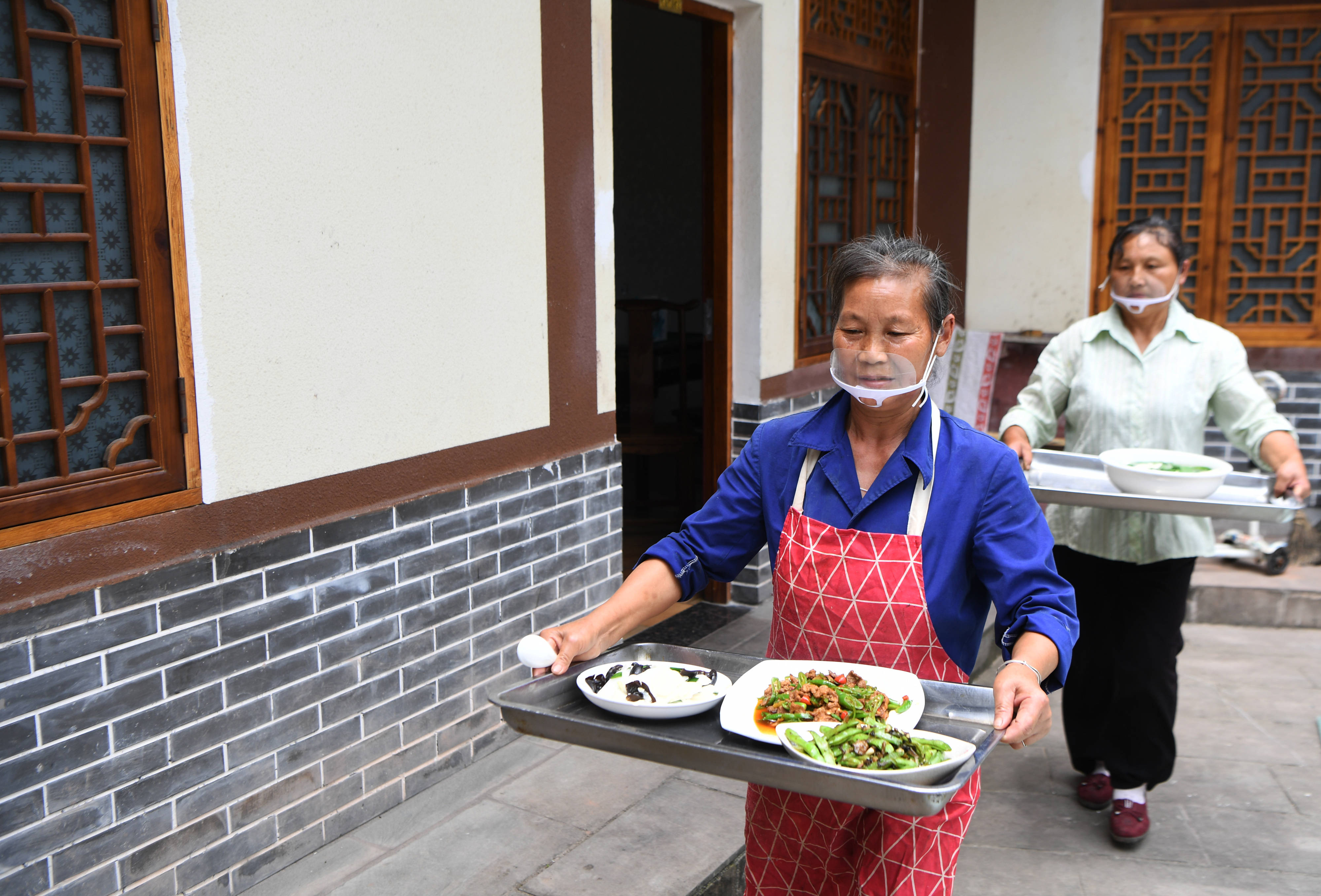 6月4日,万州区长岭镇安溪村一农家乐的工作人员在上菜