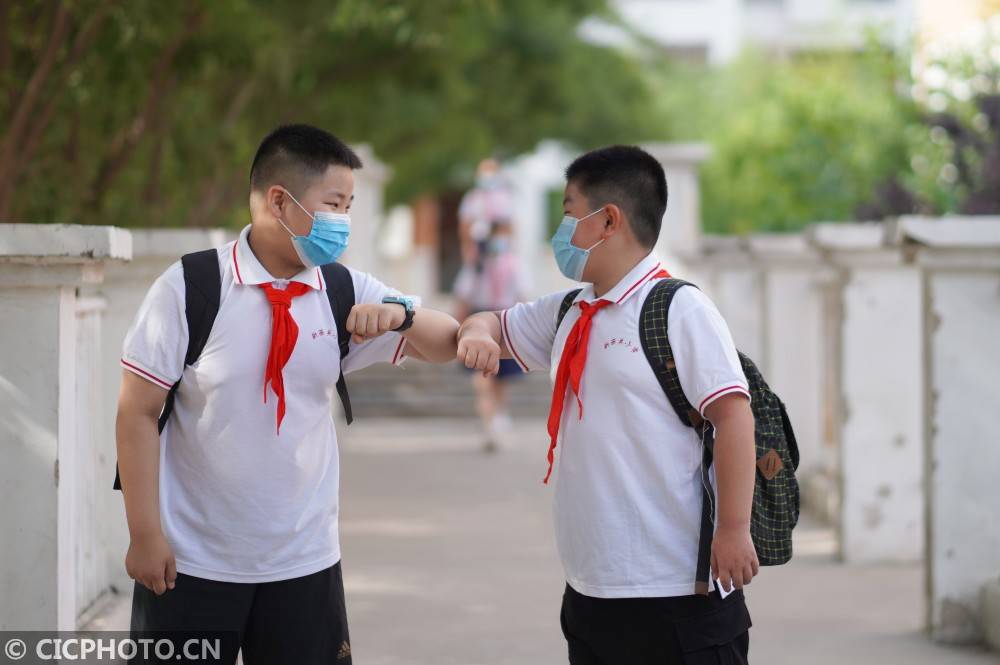 河北省邢台市内丘县新西关小学,两名学生用"碰肘"的方式打招呼