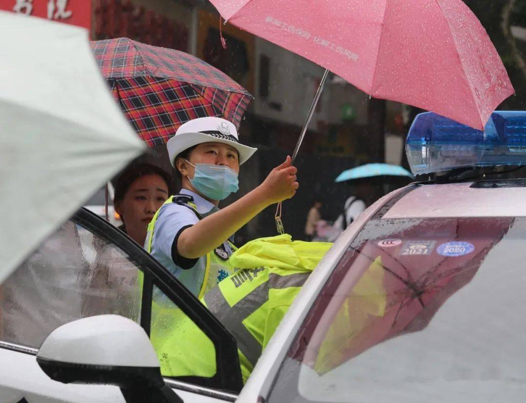 女交警在指挥大雨天机关科室人员一线支援指挥非机动车离开机动车道
