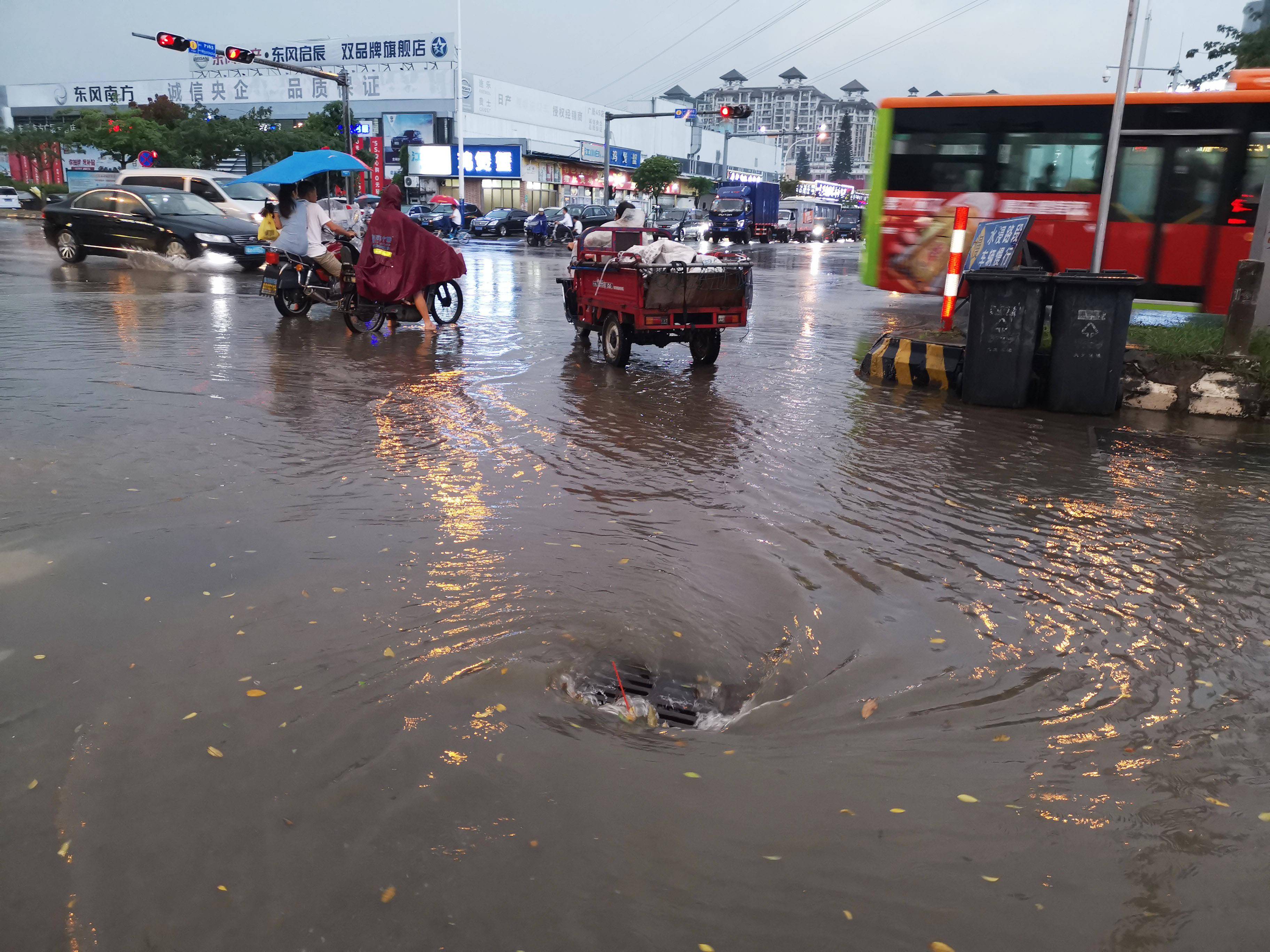 路面的雨水从高往低处流,在排水口形成漩涡