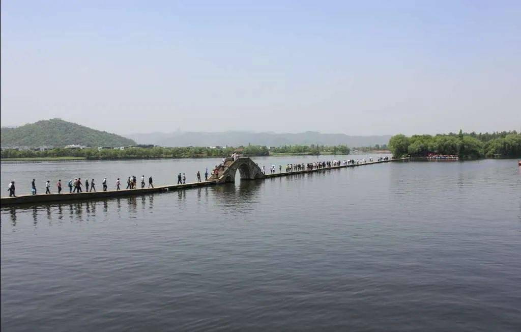 千里运河南北贯,乌蓬扁舟欸乃声.轻舟耕雪鱼跃腾,三长堤石桥撑伞人.
