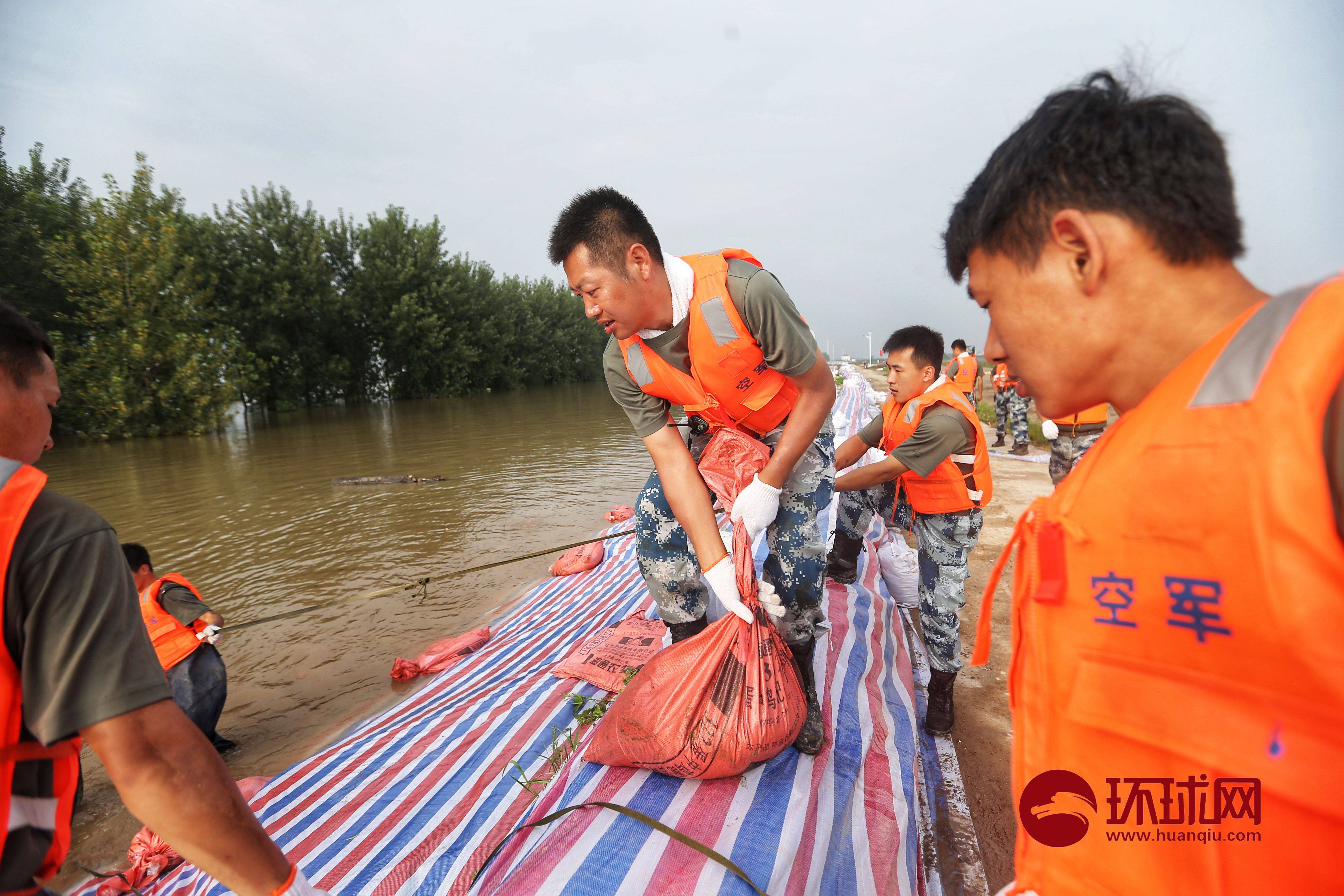 江西九江:抗洪戰士加固圩堤上水後,被倒控灌進防水褲中的江水