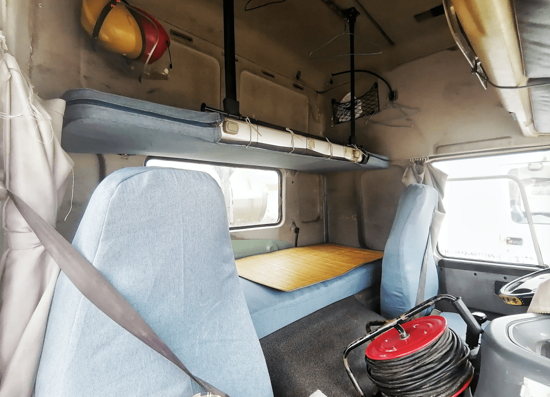 大货车的驾驶室里设有像火车硬卧一样的上下铺,空间狭小摄:未来汽车