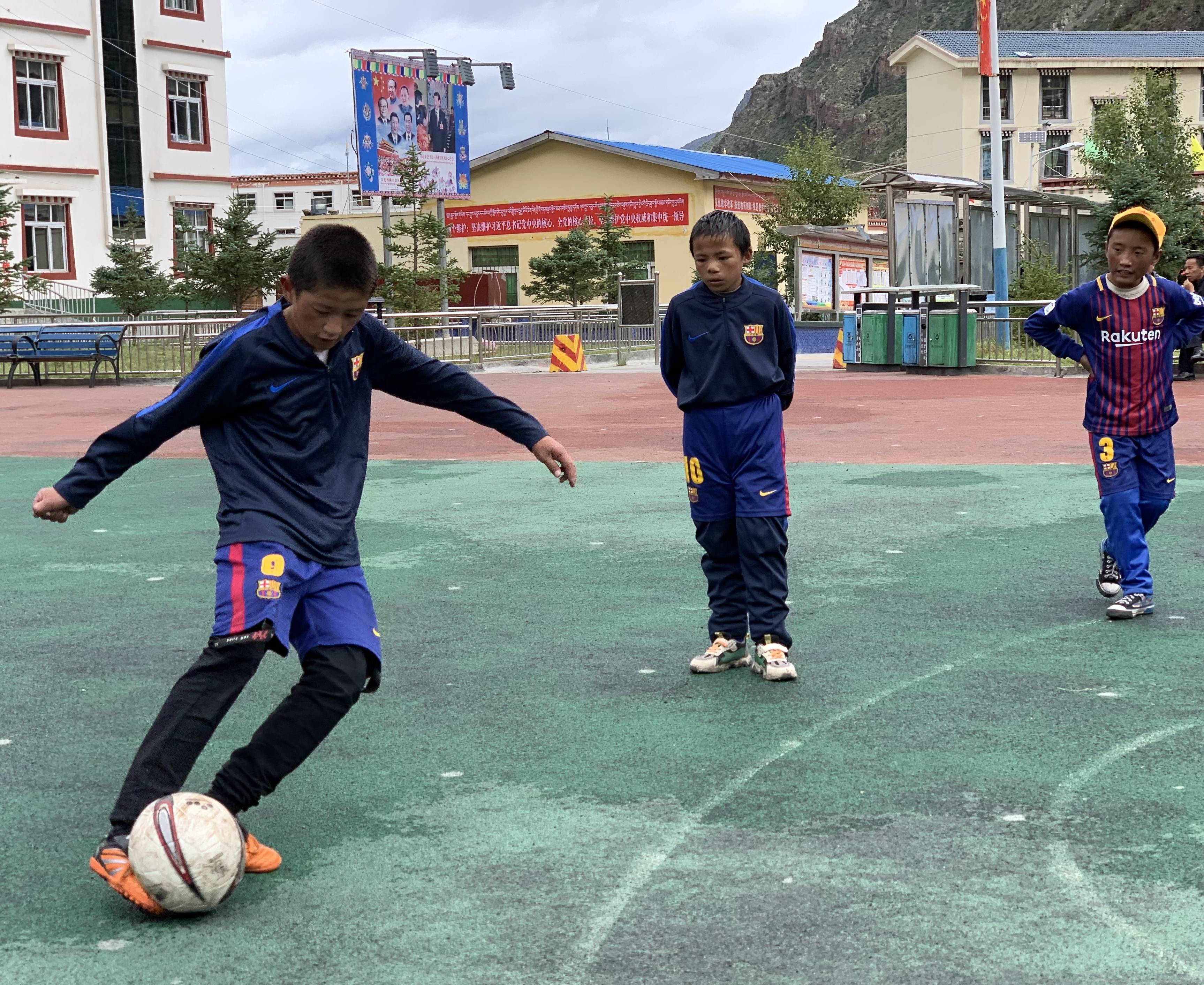 拉孜乡中心小学足球兴趣小组的学生在进行足球训练(7月29日摄.