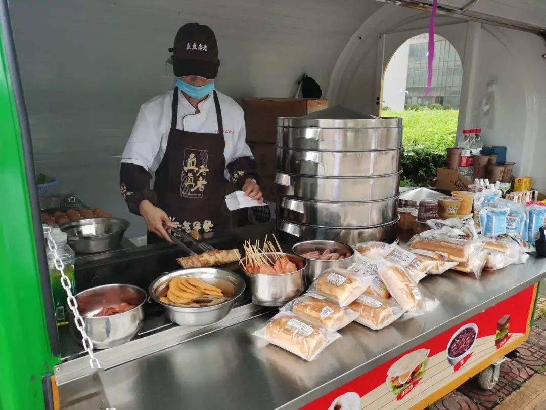 粽子,锅里煎着香喷喷的手抓饼,摊点上还摆放着热乎乎的豆浆和营养早餐