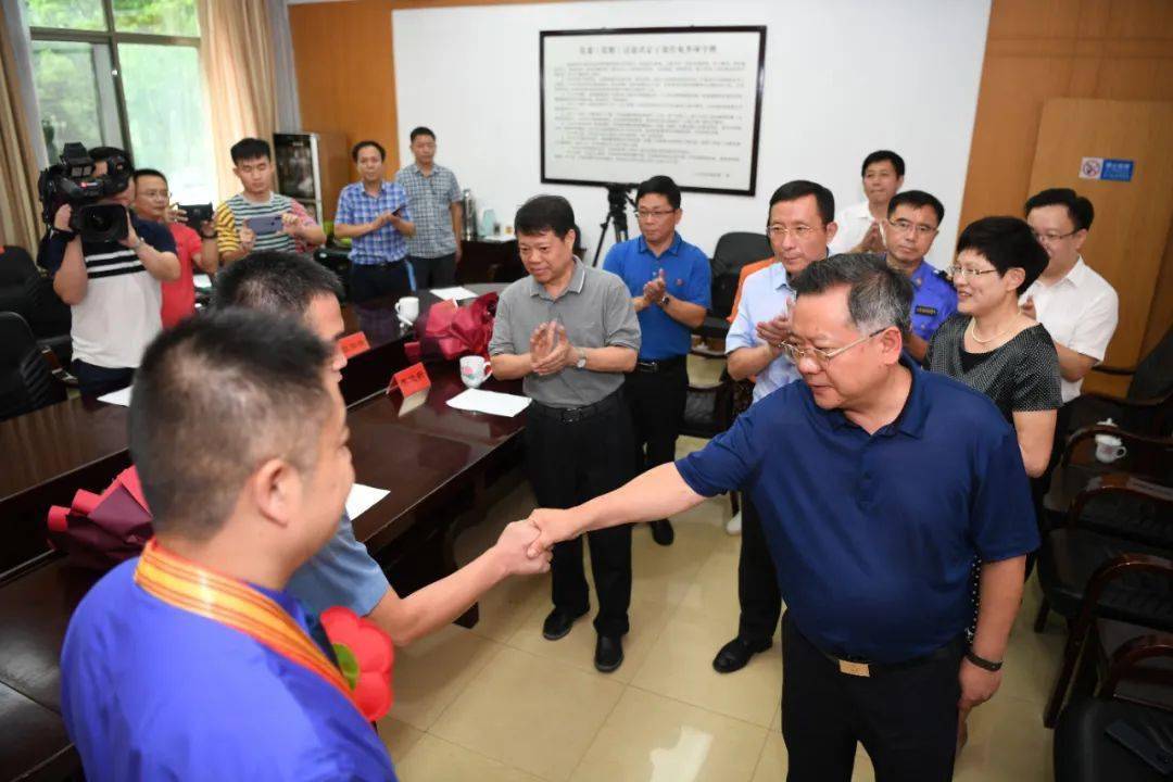 右:黄卫国接见中,易鹏飞与黄卫国,李迎新一一亲切握手,并代表市委,市