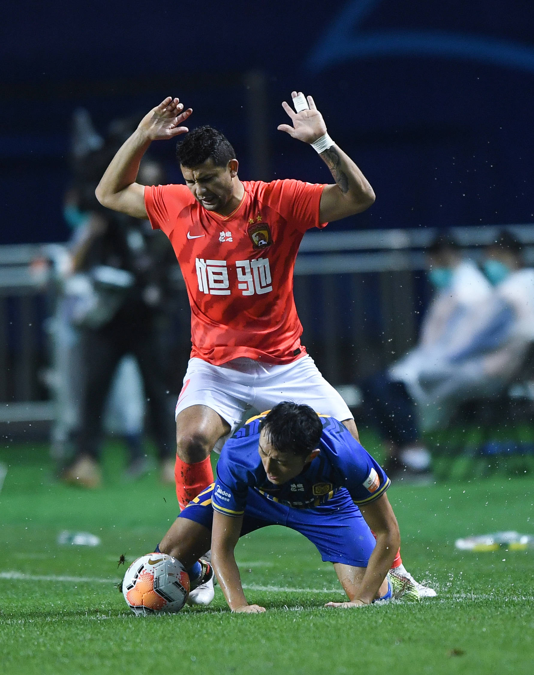 9月24日,江苏苏宁易购队球员杨博宇(下)与广州恒大淘宝队球员埃克森在