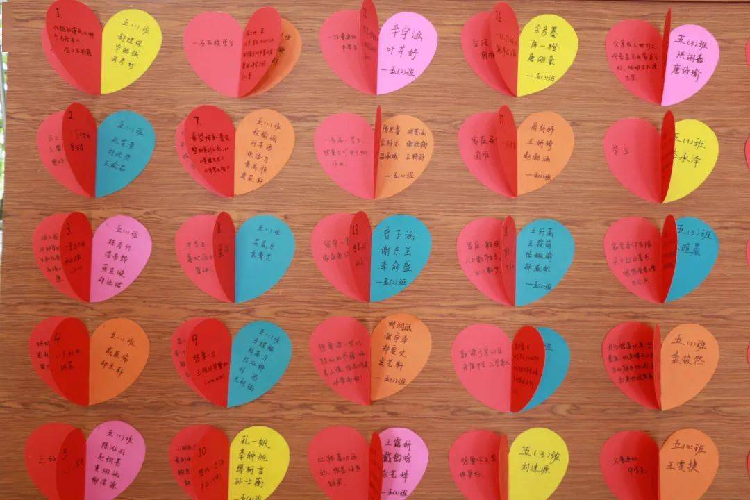 活动中,认领学生和家长拿着半颗爱心形状的认领卡走到自己心愿墙前