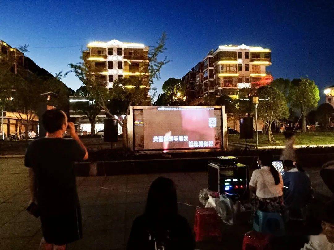 (往日广场上的 露天ktv 实拍图 )有一位小区大妈刚跟窗妹聊天为了孩子