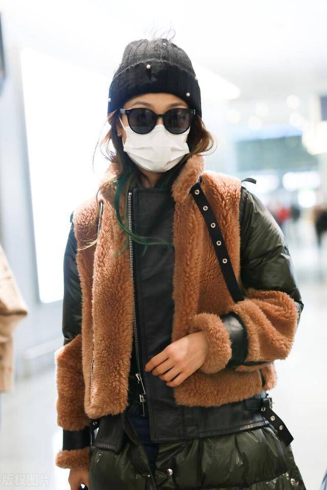 容祖儿穿拼接羽绒服现身机场挑染绿色头发让人看不懂的时尚