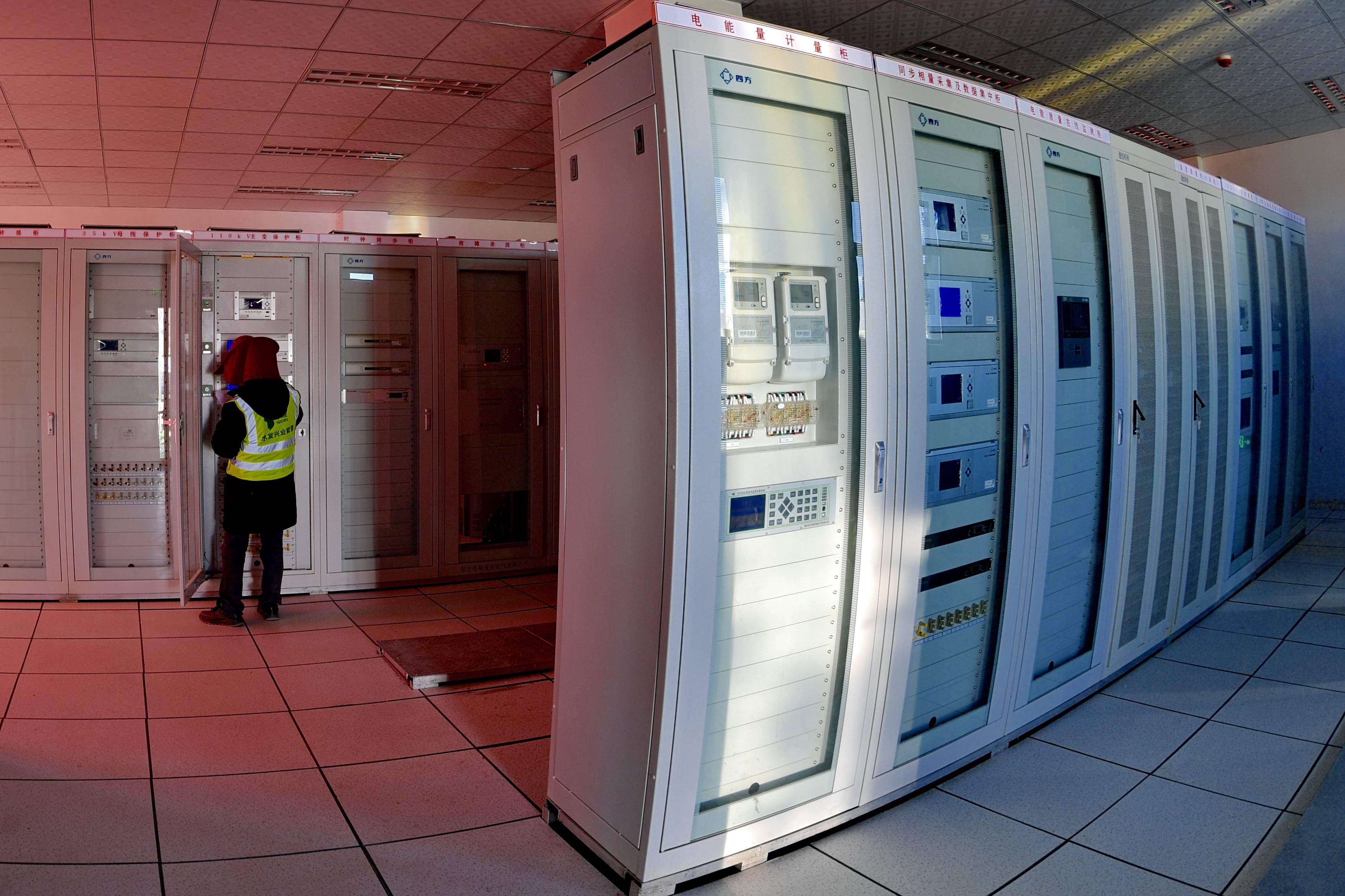 当现代生态产业示范园50兆瓦光储电站,技术人员在继电保护室调试设备