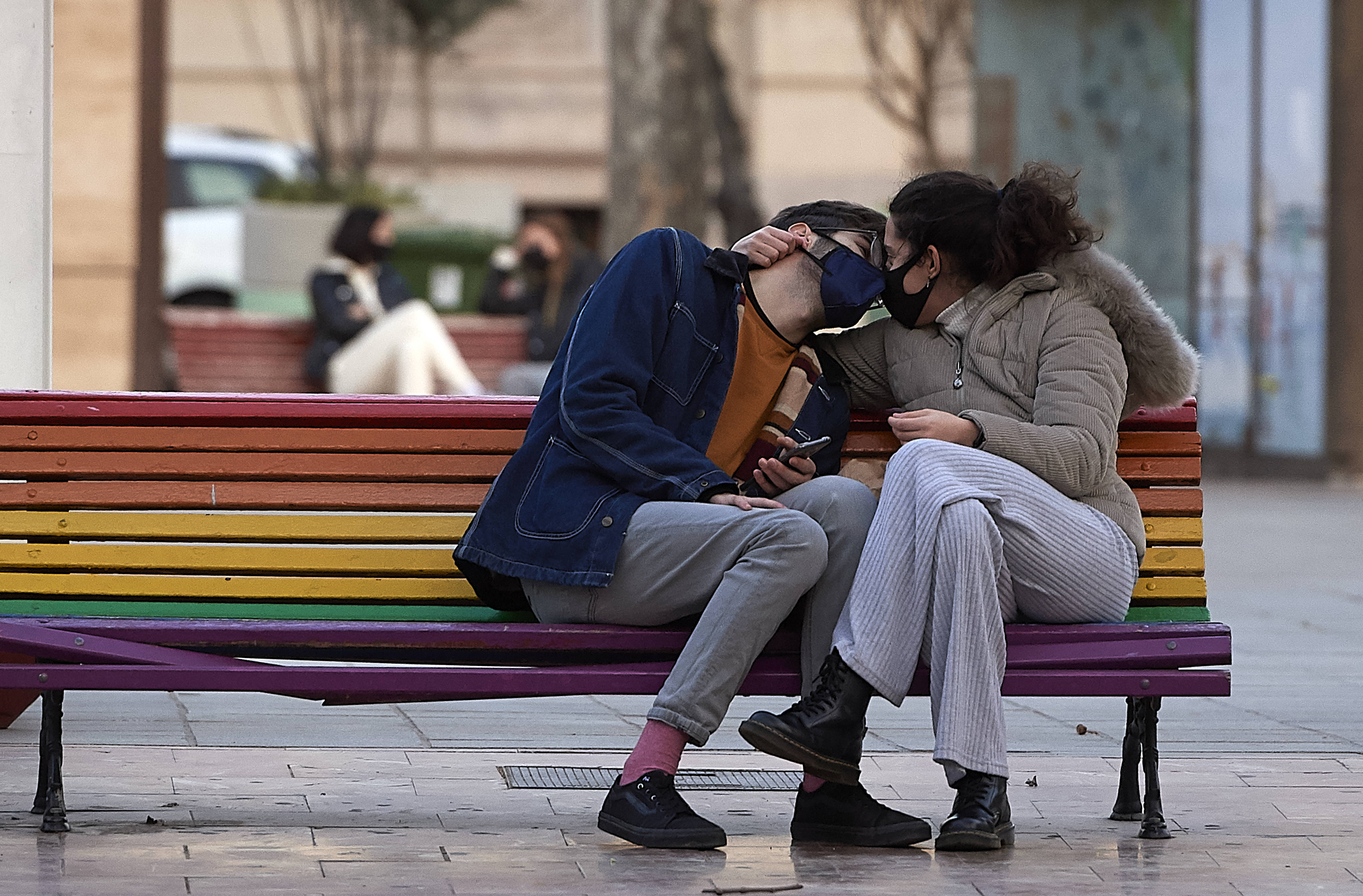 1月22日,在西班牙巴伦西亚,一对佩戴口罩的情侣依偎在一起