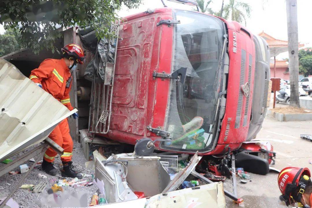 玉林一大车发生侧翻压倒路边的副食店,一人被困压在车辆底下_救援