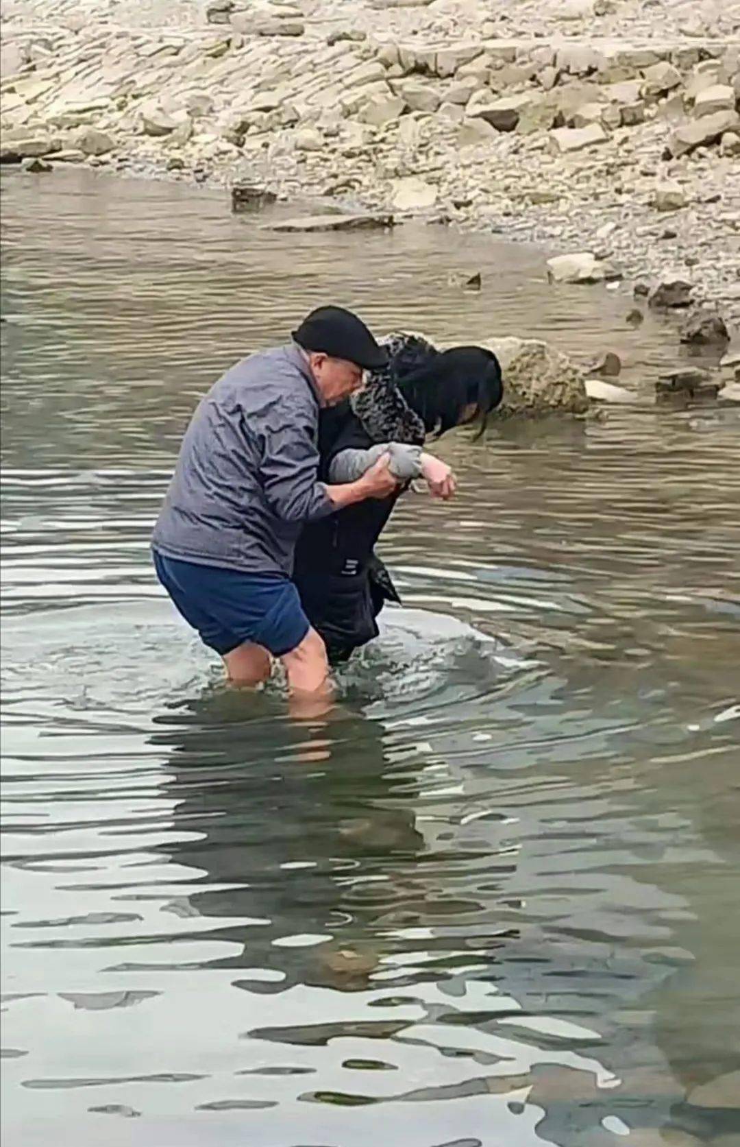 女子被韩永华扶上岸,他们夫妻俩耐心地开导女子.