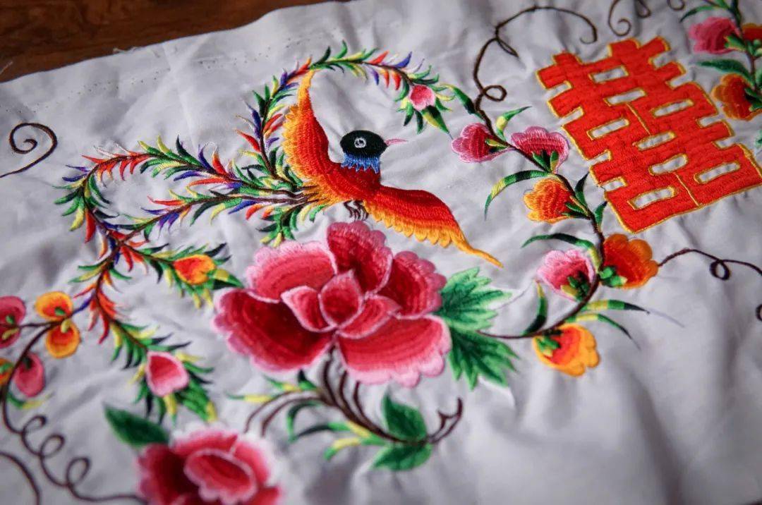 在剪纸纹样的基底下 再通过一针一线的刺绣手法 被装点在白族服饰的围