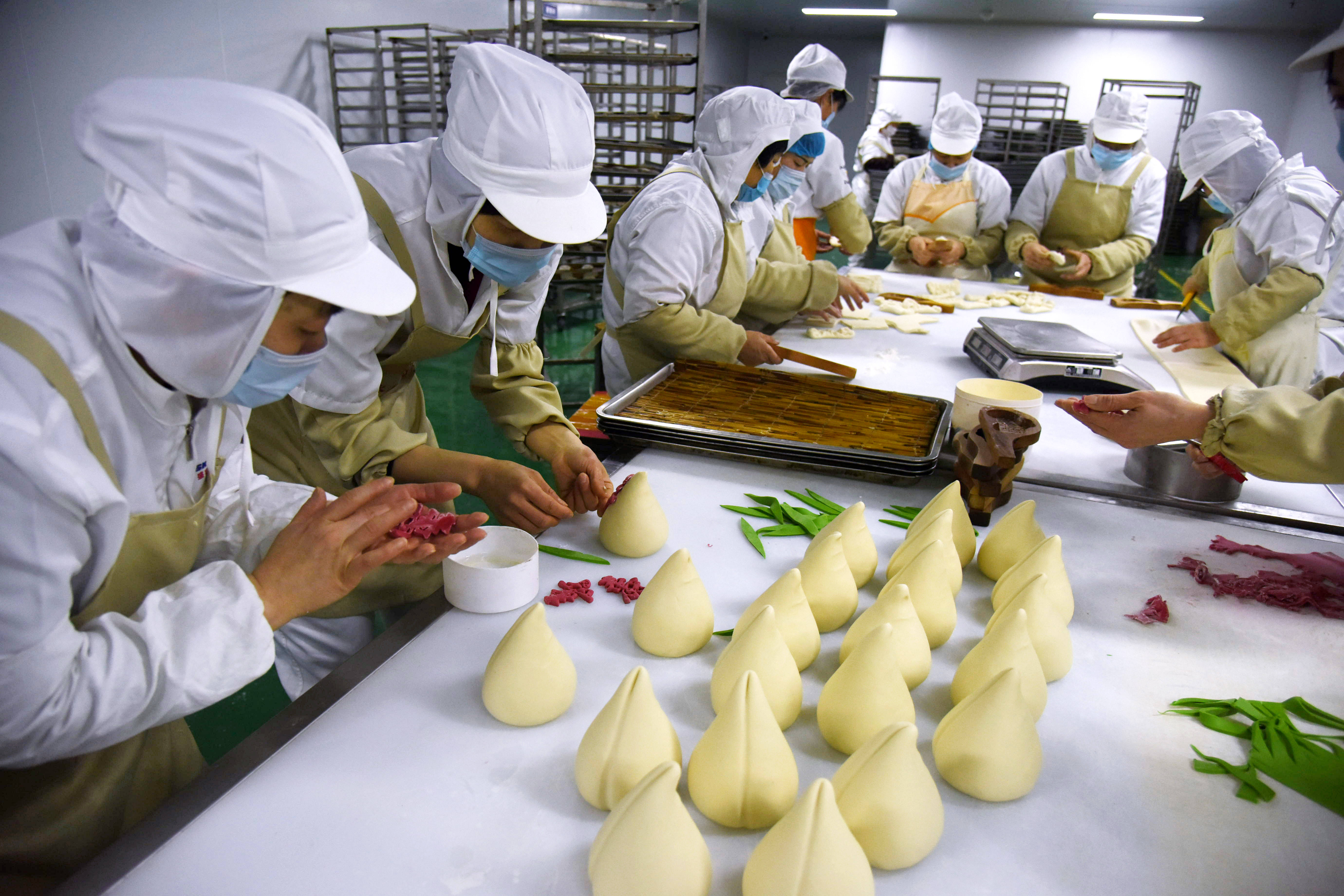 2月3日,青島市西海岸新區一食品加工廠的工人在製作傳統麵食.