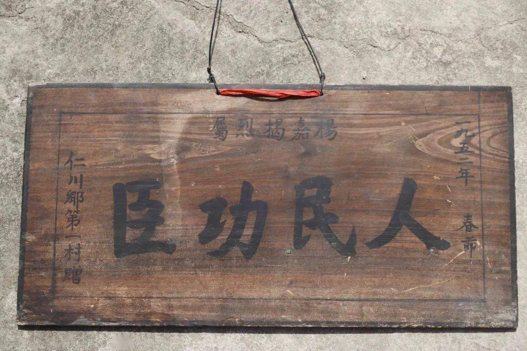 "今年67岁的杨有本从家中拿出一块写有"杨嘉揭烈士 人民功臣"的牌匾