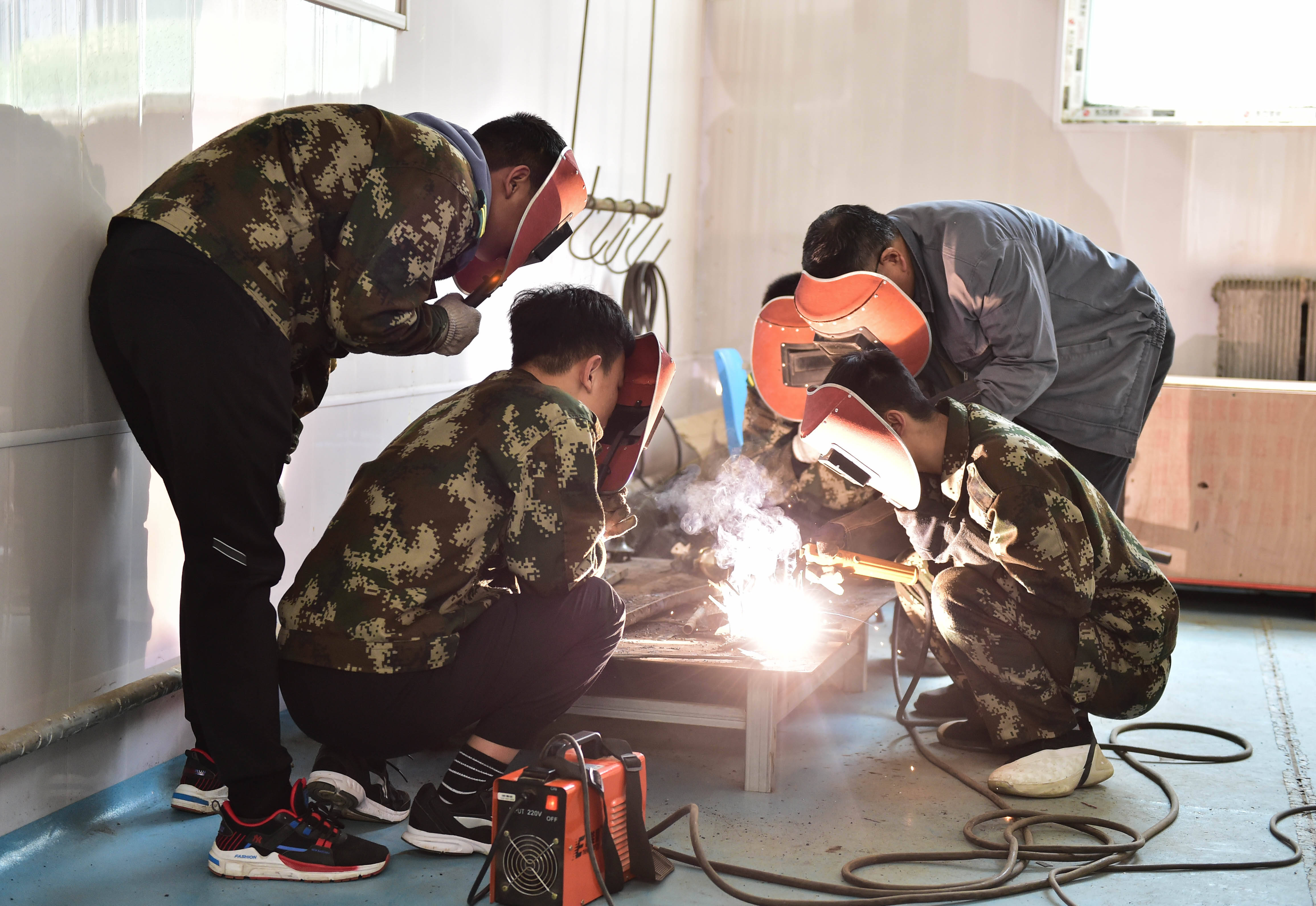 4月14日,在山西工程科技职业大学,老师在指导学生焊接.