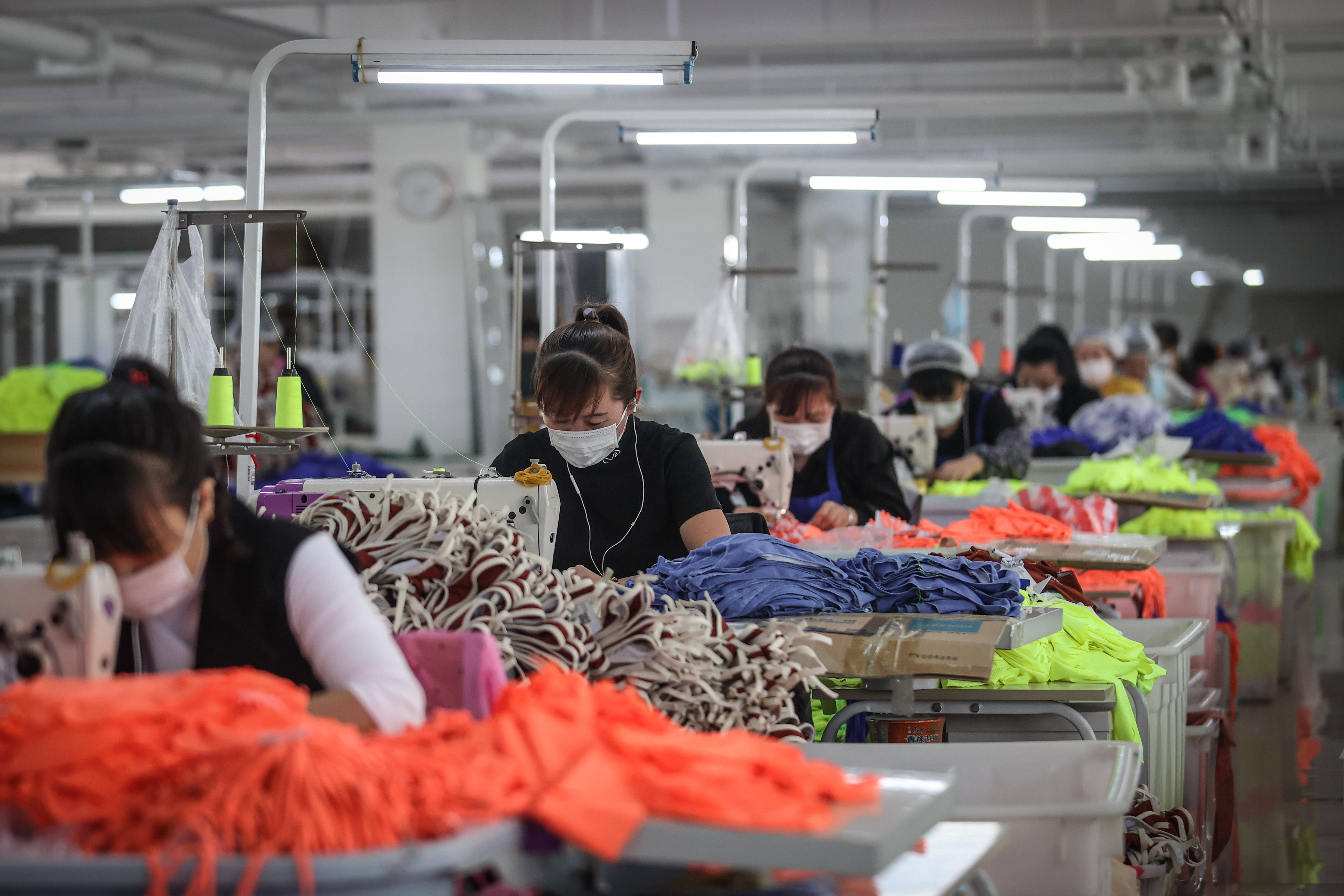 4月7日,工作人员在葫芦岛斯达威集团泳装生产车间加工泳衣