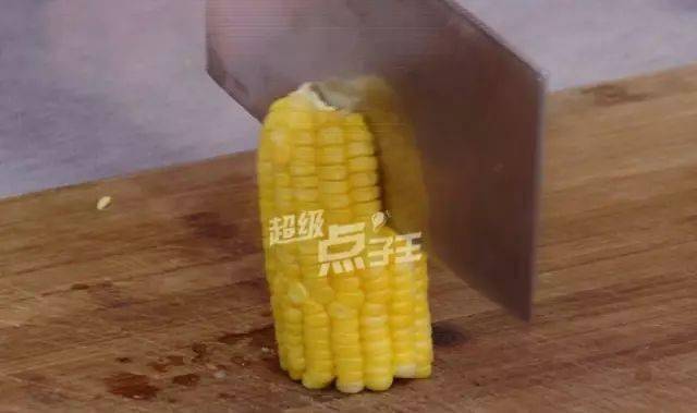 5分钟后,玉米就熟了,把它掰成两半,再用刀在中间像这样对半切开.