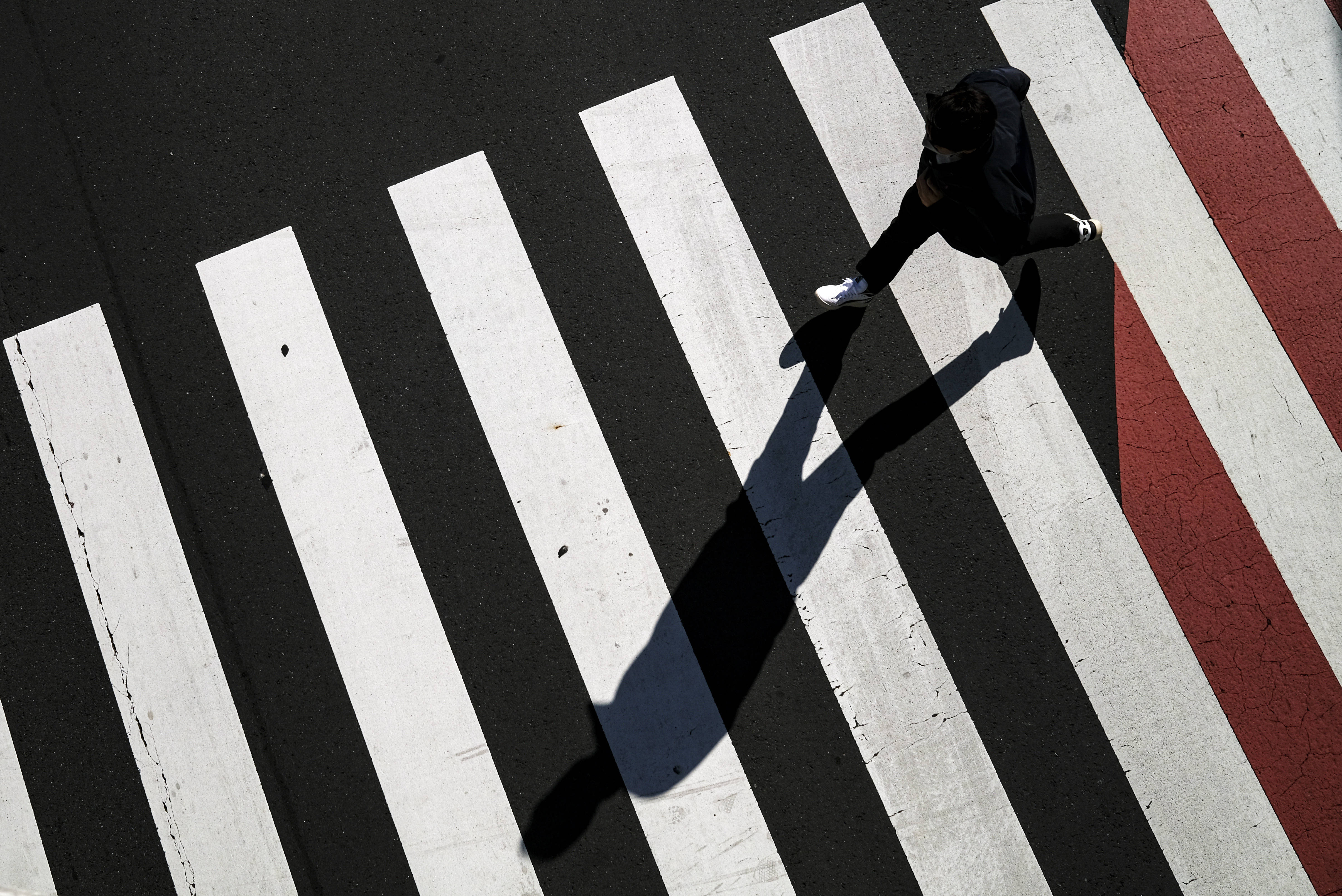 4月26日,一名跑步者在日本东京经过斑马线