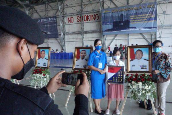 4月29日,沉没潜艇官兵的亲属在印度尼西亚泗水参加追悼会时与遗像