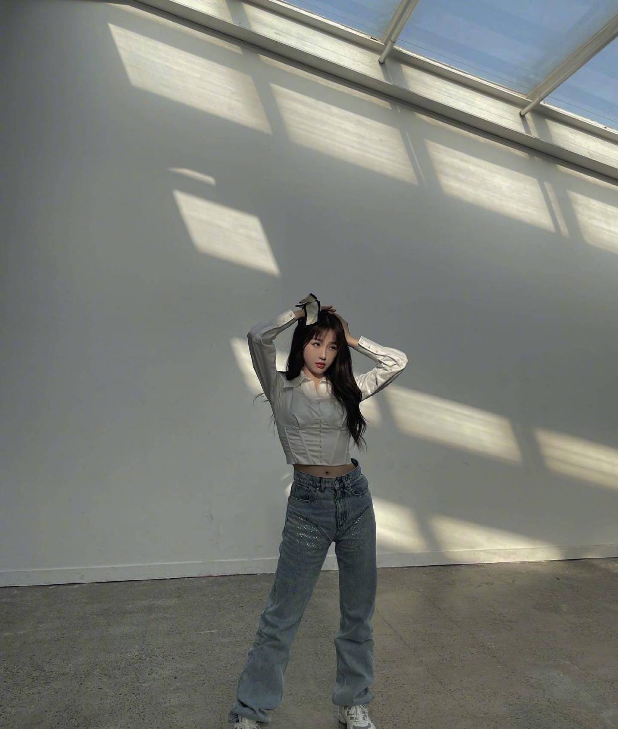照片上的虞书欣,身穿一件白色衬衫搭配一条直筒牛仔裤,看似简简单单的