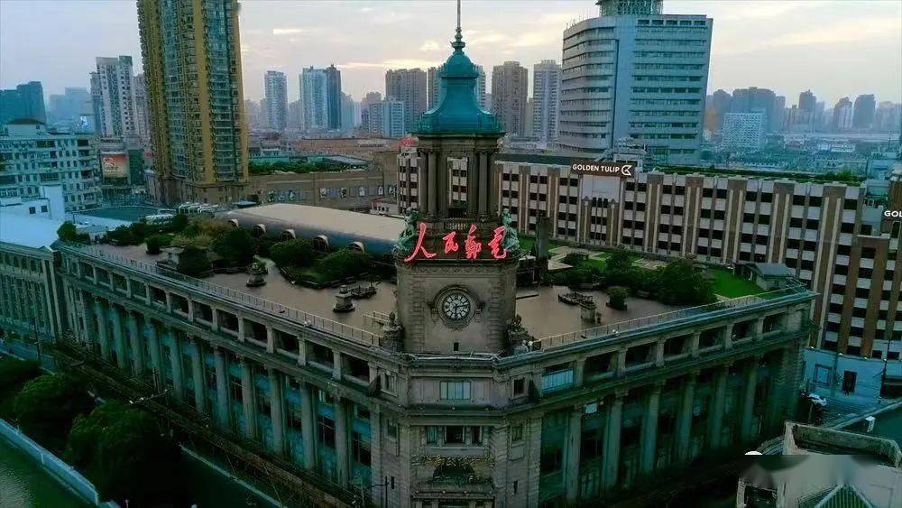 仍然屹立在苏州河畔,大楼标志性的钟楼上"人民邮电"四个大字耀眼醒目