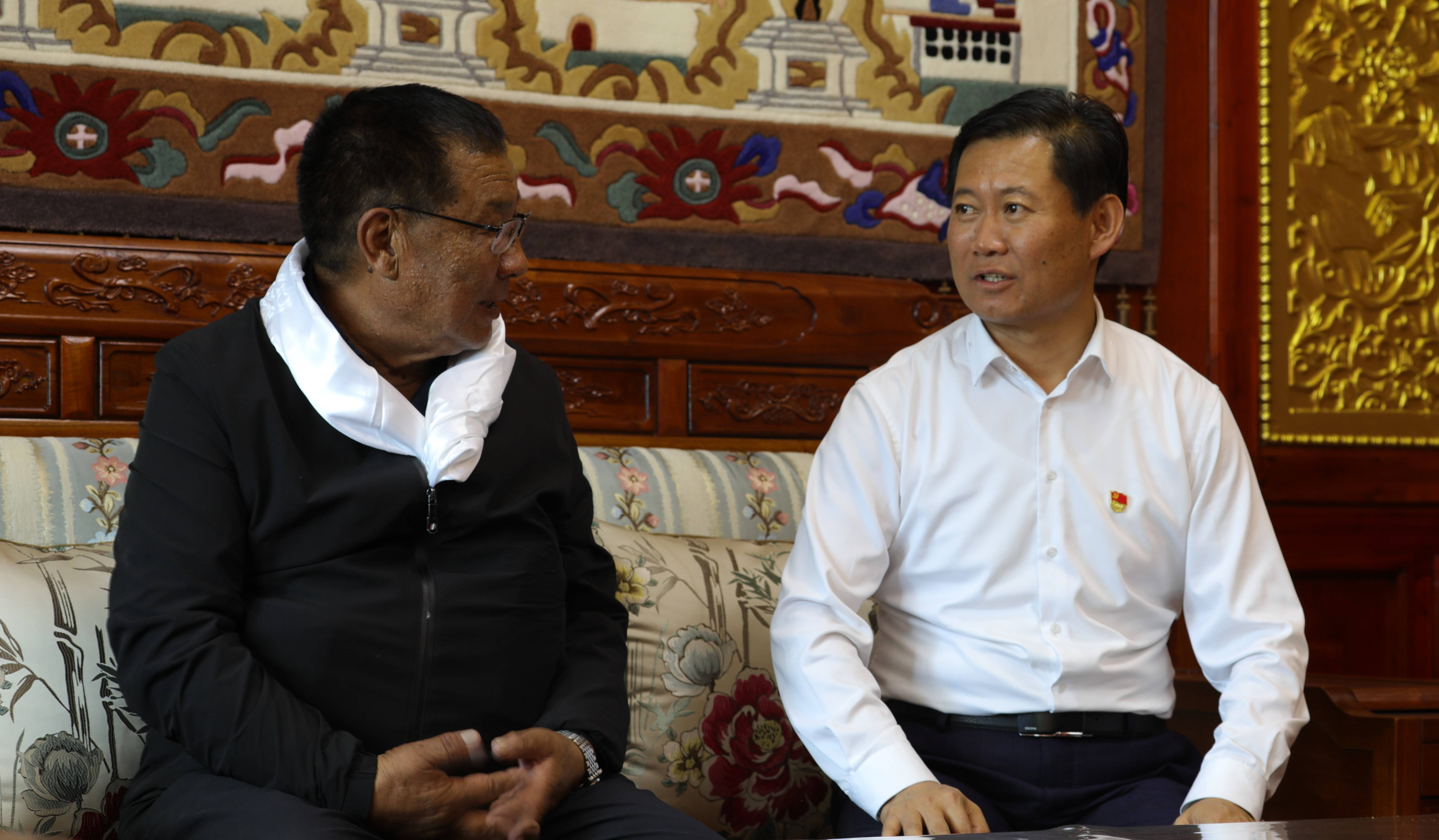 张峰(右)与青海省海南藏族自治州共和县恰卜恰镇索吉亥村村民华旦交流